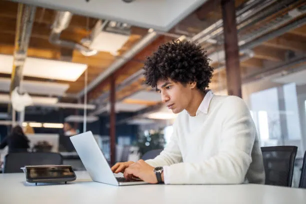 Data professional working on a laptop in a modern co-working space